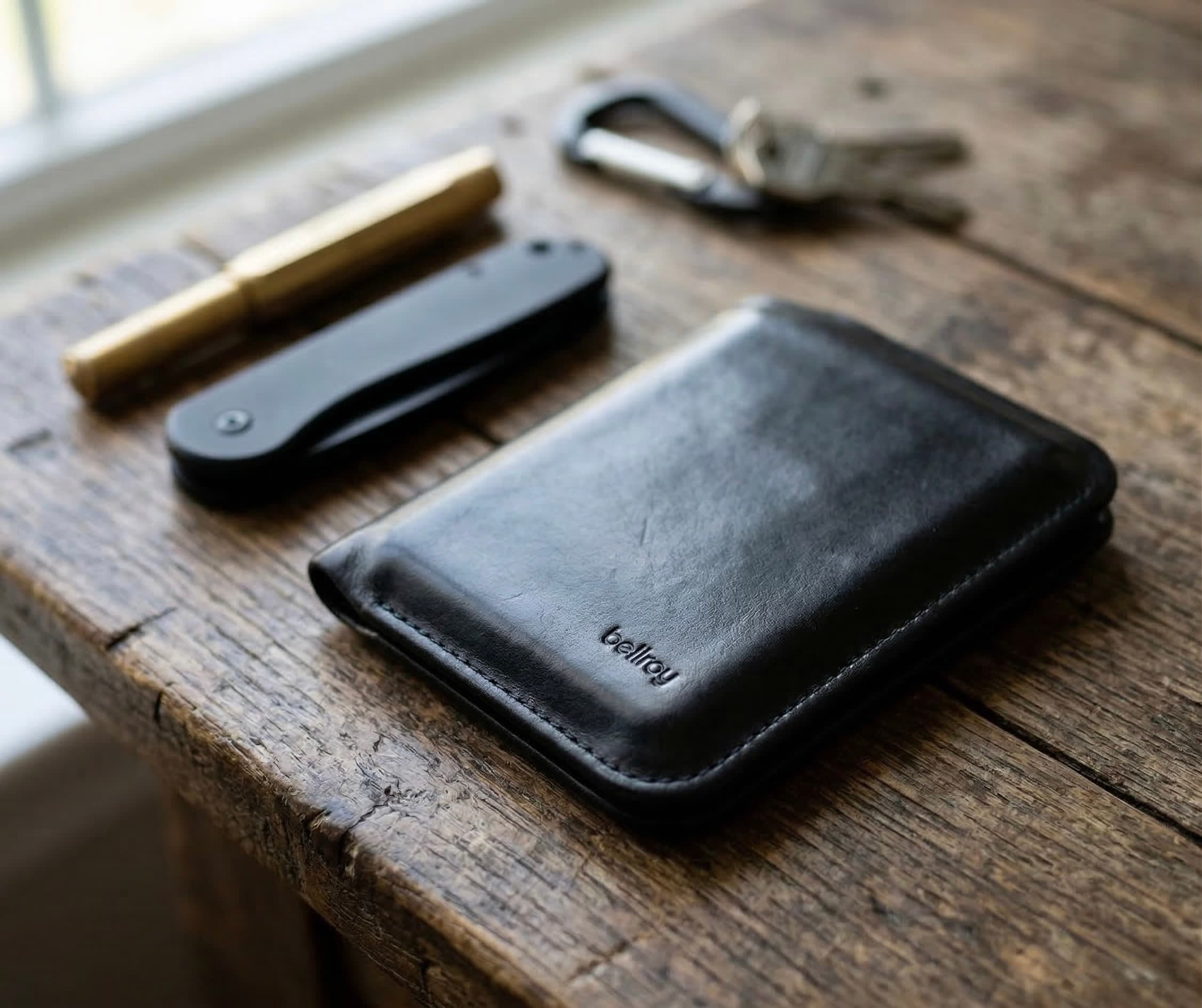 Slim wallet and keys on a wooden tray